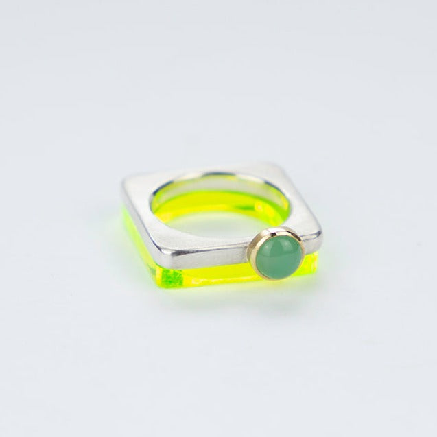 A square silver ring with a colourful cabochon set in gold.